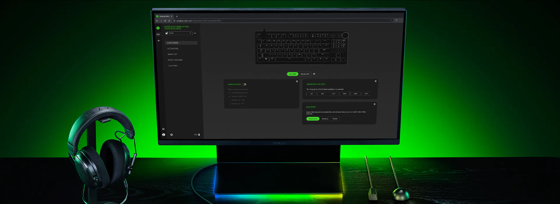 Razer Synapse Web in a browser on a monitor, with a headset and green Chroma lighting on the desk