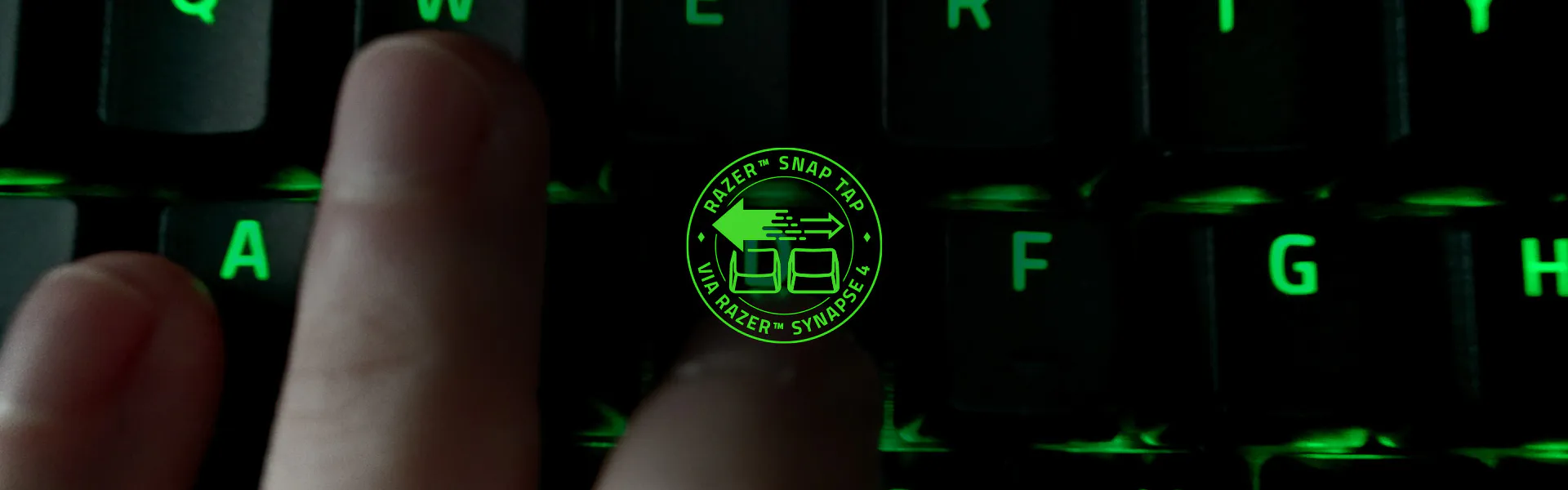 Close-up of a green-backlit Razer keyboard with the Snap Tap via Synapse 4 badge
